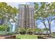 Beautiful condo building with a manicured lawn and surrounding trees at 285 Centennial Olympic Park Nw Dr # 1905, Atlanta, GA 30339