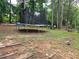 The backyard shows a trampoline nestled between trees and underbrush at 3293 Oakcliff Rd, Doraville, GA 30340
