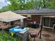 Untidy backyard with an umbrella, random furniture, and grilling equipment on a concrete pad at 3293 Oakcliff Rd, Doraville, GA 30340