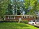 Charming brick ranch-style home with lush front lawn and manicured hedges, plus a white SUV parked on the side at 3293 Oakcliff Rd, Doraville, GA 30340