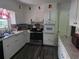 Functional kitchen featuring white cabinets, updated appliances, and durable laminate floors at 3293 Oakcliff Rd, Doraville, GA 30340