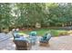 Secluded backyard oasis featuring a stone patio and comfortable seating nestled among mature trees at 575 Valley Hall Dr, Sandy Springs, GA 30350