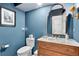 Stylish powder room with blue walls, a decorative mirror, and unique vanity at 575 Valley Hall Dr, Sandy Springs, GA 30350