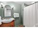 Cozy bathroom with wood vanity, and shower with white curtain at 575 Valley Hall Dr, Sandy Springs, GA 30350