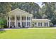 Beautiful two-story home featuring white columns, a green lawn, and mature trees at 575 Valley Hall Dr, Sandy Springs, GA 30350