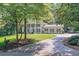 Beautiful view of the home's front exterior from the driveway with lush surroundings at 575 Valley Hall Dr, Sandy Springs, GA 30350