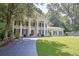 Spacious front exterior showcases the home's lawn, mature trees, and classic column design at 575 Valley Hall Dr, Sandy Springs, GA 30350