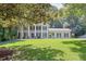 Stately two-story home with columns, black shutters, green lawn, and mature shade trees at 575 Valley Hall Dr, Sandy Springs, GA 30350