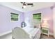 Bedroom with carpet flooring, a ceiling fan, windows, and lavender walls at 2142 Troutdale Dr, Decatur, GA 30032