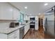 Modern kitchen with white cabinets, granite countertops, stainless steel appliances and hardwood floors at 2142 Troutdale Dr, Decatur, GA 30032