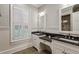 Elegant bathroom featuring double vanities with black granite countertops, beadboard, and shuttered window at 2671 Bohler Nw Rd, Atlanta, GA 30327