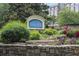 Landscaped entrance sign for Vinings View Condominiums with stone base, lush greenery and colorful flowers at 3160 Seven Pines Unit 105 Ct, Atlanta, GA 30339