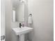 Modern half-bathroom featuring a pedestal sink, black fixtures, and neutral tones at 402 Retreat Ln, Canton, GA 30114