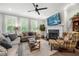 Bright living room with a cozy fireplace, ceiling fan, and large windows with stylish shutters at 402 Retreat Ln, Canton, GA 30114