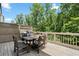 Cozy deck with wooden furniture surrounded by lush greenery and blue skies at 402 Retreat Ln, Canton, GA 30114