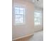 Bright bedroom featuring carpeted floors and two large windows offering outdoor views at 235 Orchard Dr, Covington, GA 30014