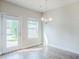 Cozy dining area filled with light from the door and window, showcasing a modern chandelier at 235 Orchard Dr, Covington, GA 30014