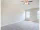 Bright main bedroom with two windows, a fan, and neutral carpet at 235 Orchard Dr, Covington, GA 30014