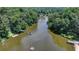 Aerial view of a lake inlet with a boat, docks, and waterfront houses surrounded by trees at 8805 Lake Dr, Snellville, GA 30039