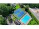 Aerial view of a community pool, tennis courts, and surrounding green landscape at 8805 Lake Dr, Snellville, GA 30039