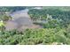 Aerial view capturing the home's lakefront setting with lush greenery and mature trees at 8805 Lake Dr, Snellville, GA 30039