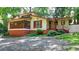 Charming home featuring a brick foundation, inviting porch, and freshly painted wood siding nestled among mature trees at 8805 Lake Dr, Snellville, GA 30039