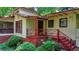 Charming home exterior featuring a red-railed porch, red shutters, and lush landscaping at 8805 Lake Dr, Snellville, GA 30039