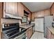Well-equipped kitchen with an oven, granite countertops, and wood cabinets at 8805 Lake Dr, Snellville, GA 30039