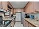 Functional kitchen with tile floors, wood cabinets, granite countertops, and stainless steel appliances at 8805 Lake Dr, Snellville, GA 30039