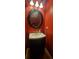 Stylish powder room features a black vanity, round mirror, and striking red walls at 1788 Arbor Gate Dr # 1505, Lawrenceville, GA 30044
