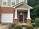 Inviting brick townhome entrance, showcasing a well-manicured lawn and an attached single-car garage at 1788 Arbor Gate Dr # 1505, Lawrenceville, GA 30044
