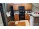 Modern kitchen featuring stainless steel appliances, warm wood cabinets, and a breakfast bar at 1788 Arbor Gate Dr # 1505, Lawrenceville, GA 30044