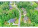 An aerial view shows a pool, multiple houses, and tree lined streets within a quiet neighborhood at 205 Camden Creek Ct, Lawrenceville, GA 30043