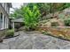 Landscaped backyard with a stone patio and lush greenery at 205 Camden Creek Ct, Lawrenceville, GA 30043