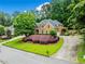 Beautiful brick home featuring an expansive green lawn, mature landscaping, and a circular driveway at 205 Camden Creek Ct, Lawrenceville, GA 30043