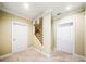 Spacious hallway with 2 doors on the right, leading to stairs with metal railing, and carpet at 205 Camden Creek Ct, Lawrenceville, GA 30043
