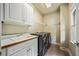 Well-equipped laundry room with a sink, cabinets, countertop, and modern washer/dryer at 205 Camden Creek Ct, Lawrenceville, GA 30043