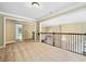 A large loft with carpet, overlooking a staircase, and an open doorway creates a welcoming living space at 205 Camden Creek Ct, Lawrenceville, GA 30043