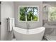 Modern bathroom with a sleek standalone tub next to a large window offering a private nature view at 2297 Nesbitt Ne Dr, Brookhaven, GA 30319