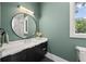 Modern bathroom with a sleek vanity, round mirror, and a window with tree views at 2297 Nesbitt Ne Dr, Brookhaven, GA 30319