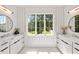 Bright bathroom with herringbone flooring, a large window, and dual vanities offers ample space and natural light at 2297 Nesbitt Ne Dr, Brookhaven, GA 30319