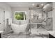 Elegant bathroom featuring a tub, glass-enclosed shower, and a large window for natural light at 2297 Nesbitt Ne Dr, Brookhaven, GA 30319