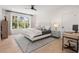 Bright bedroom boasts hardwood floors, a ceiling fan, a bed, a desk and expansive windows for natural light at 2297 Nesbitt Ne Dr, Brookhaven, GA 30319