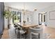 Bright dining room with a modern chandelier, large windows, light wood floors, and chic decor at 2297 Nesbitt Ne Dr, Brookhaven, GA 30319