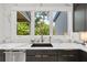 Kitchen sink with marble countertops and a view of the lush greenery outside at 2297 Nesbitt Ne Dr, Brookhaven, GA 30319