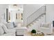 Bright living room with white furniture, hardwood floors, and staircase at 2297 Nesbitt Ne Dr, Brookhaven, GA 30319