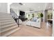 Open living room with a sleek fireplace, light wood floors, staircase, and ample natural light at 2297 Nesbitt Ne Dr, Brookhaven, GA 30319