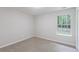 Bedroom featuring light walls, neutral carpet, and a window overlooking greenery at 4271 Brighton Nw Way, Kennesaw, GA 30144