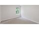 Bedroom featuring light walls, neutral carpet, and a window overlooking greenery at 4271 Brighton Nw Way, Kennesaw, GA 30144