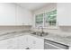 Clean kitchen with white cabinets, countertops, and a stainless steel sink at 4271 Brighton Nw Way, Kennesaw, GA 30144